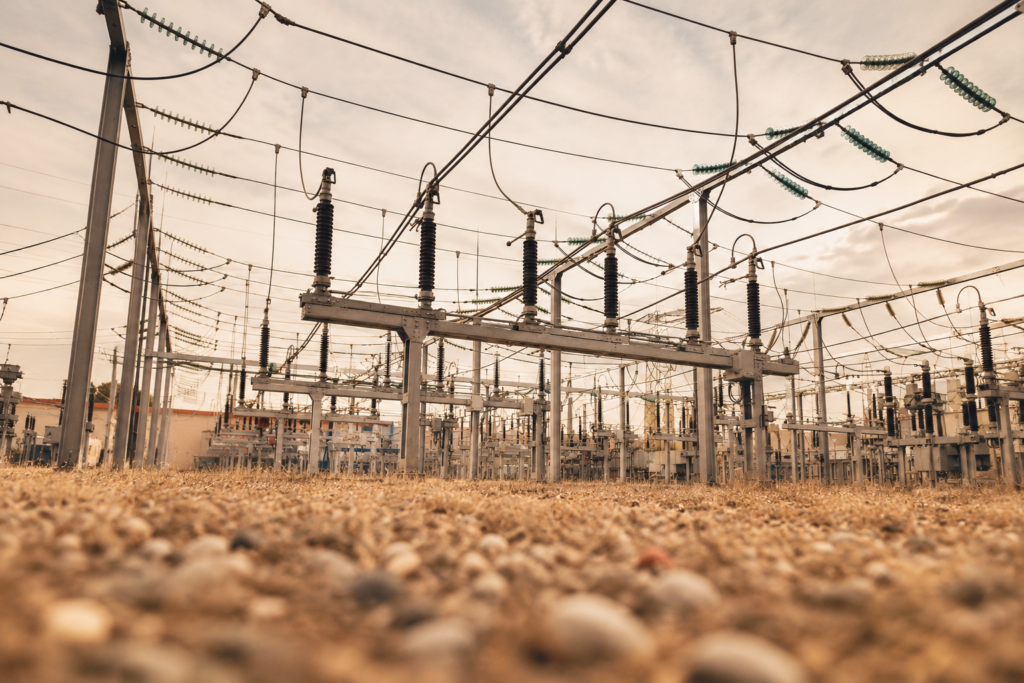 Electrical substation with high-voltage power lines and grid infrastructure at sunset