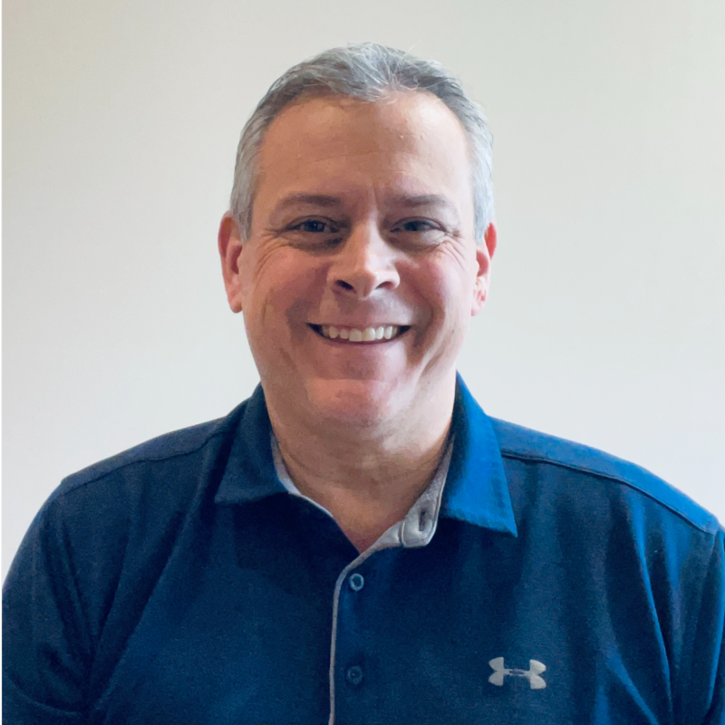Professional portrait of an Evora team member smiling in a blue polo shirt.