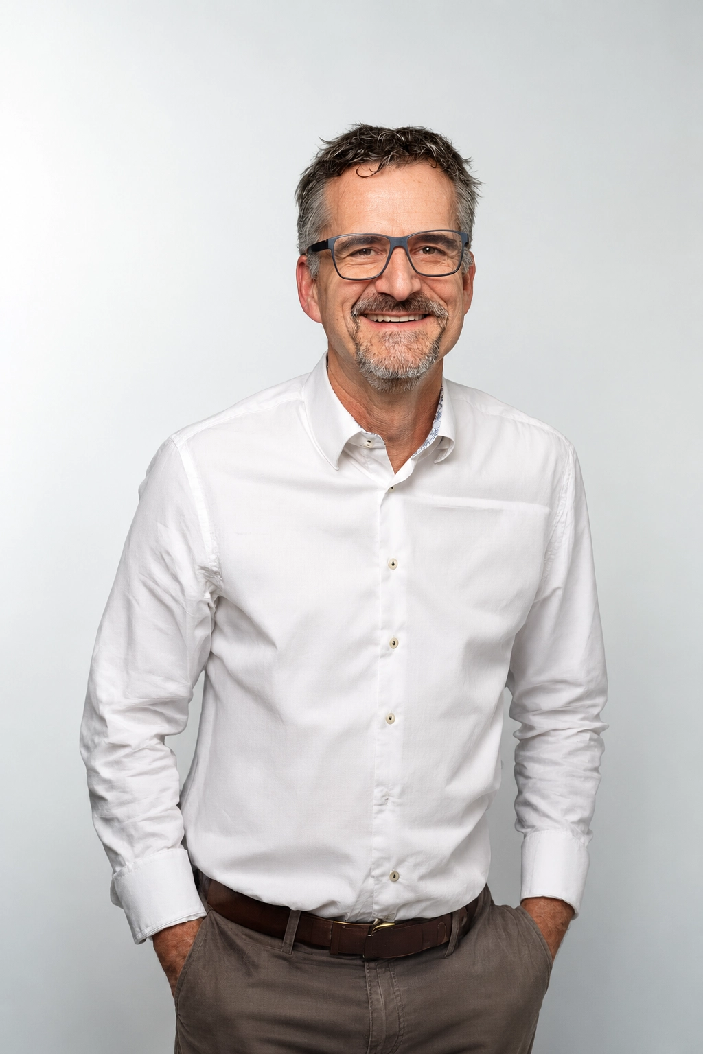 Evora consultant, Sebastian Bloch, smiling in a white business shirt during a professional studio portrait.
