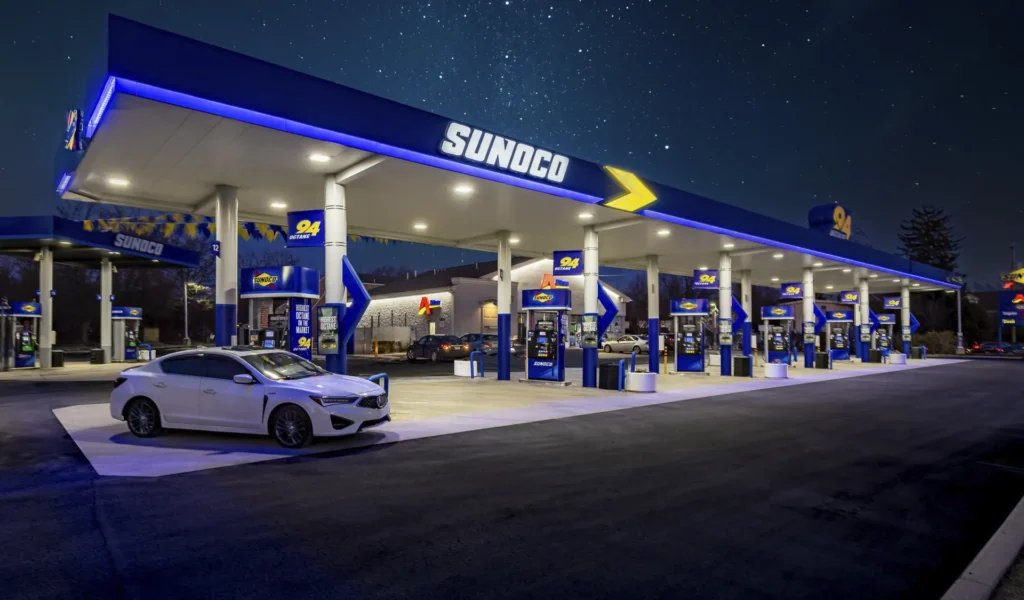 Sunoco gas station at night with illuminated fuel pumps and service canopy