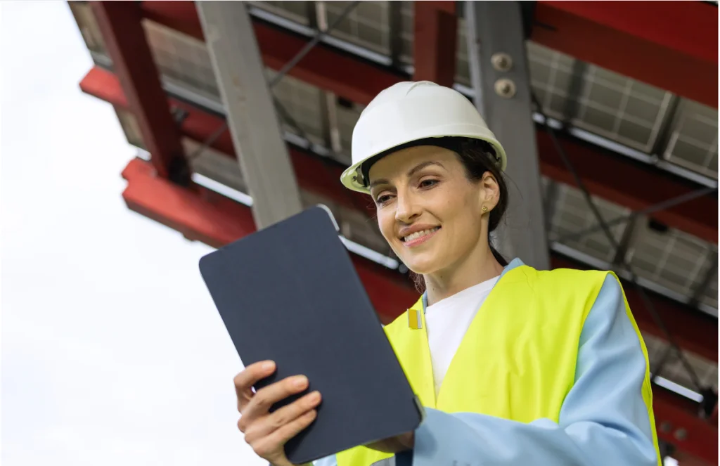 Female field engineer using a tablet for solar energy inspection and digital maintenance